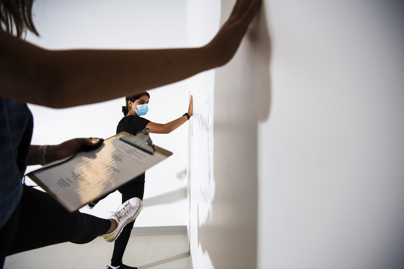 A study participant performs an exercise as a researcher looks on