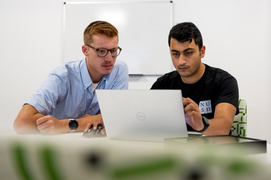 Two engineering students work on their computers