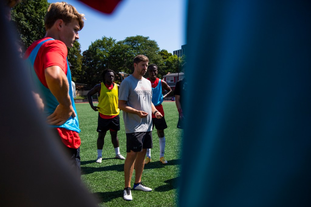 Soccer coach speaks with players on field