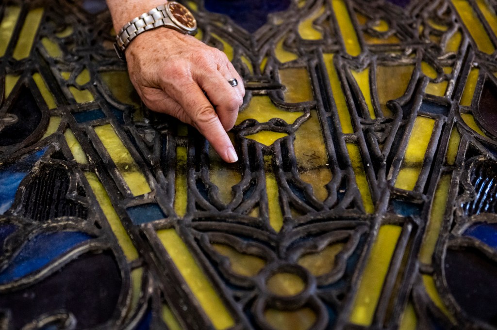 hand pointing to stained glass window