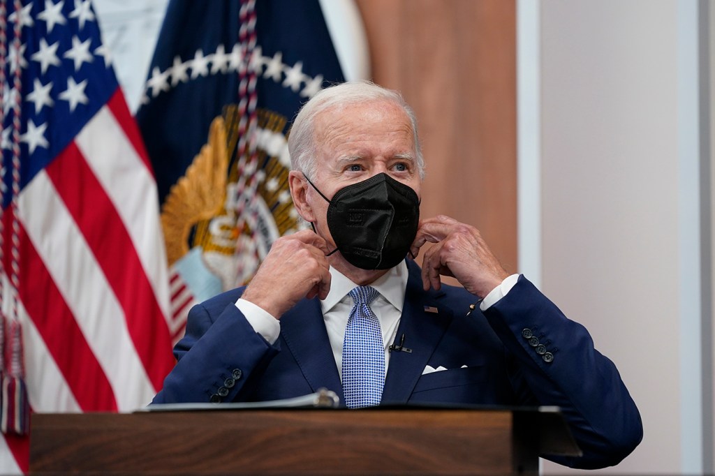 old man wear black kn95 mask standing in front of us flag