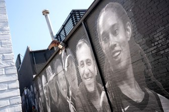 brick wall with mural of peoples faces