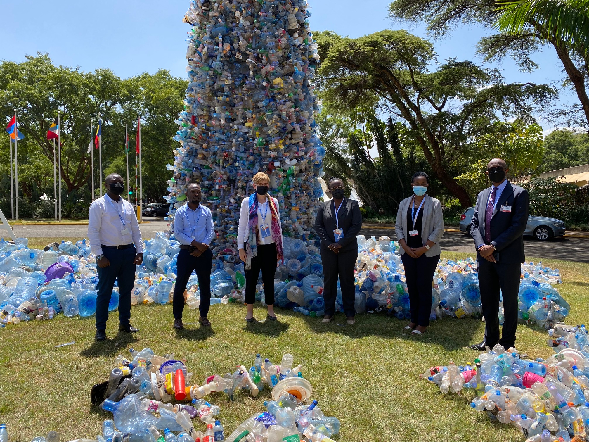 People stand by art installation of plastic pollution. 