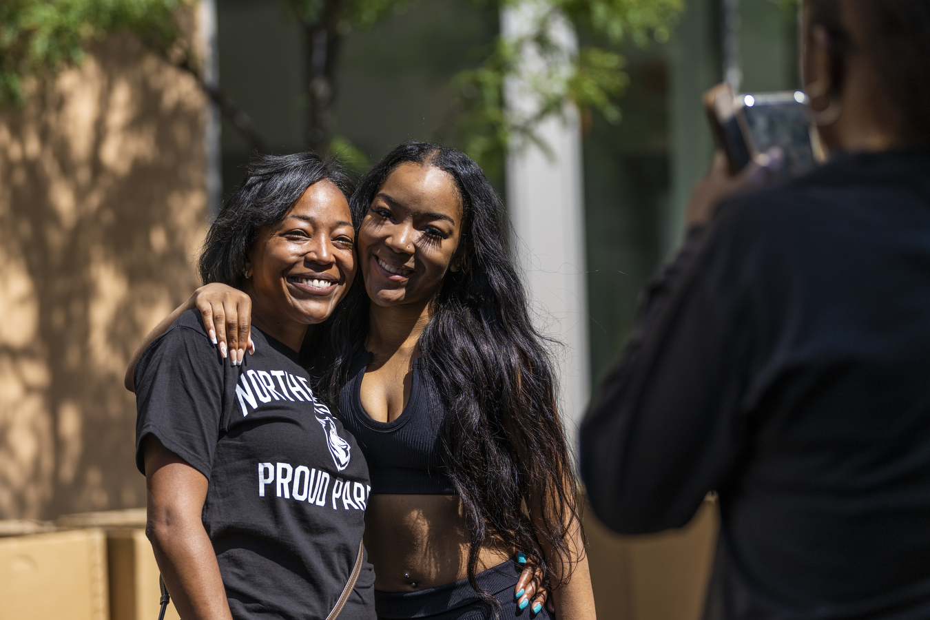 A parent is smiling with their child while taking a picture. 