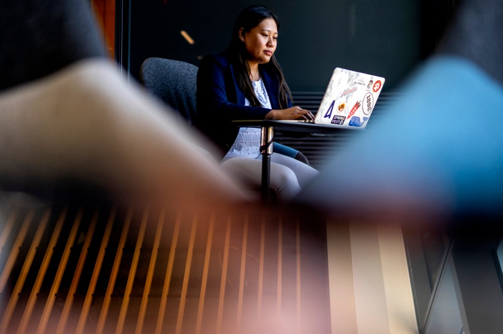 Sophia Ly sits at a laptop working