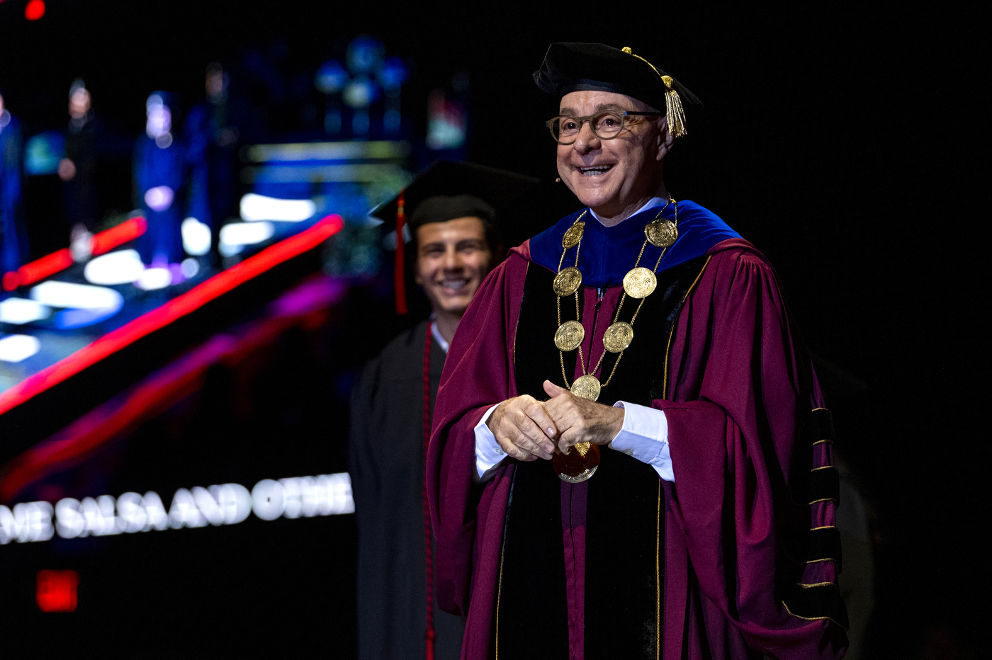 A person wearing a large red robe and a golden necklace is standing at Northeastern's 2022 Convocation.