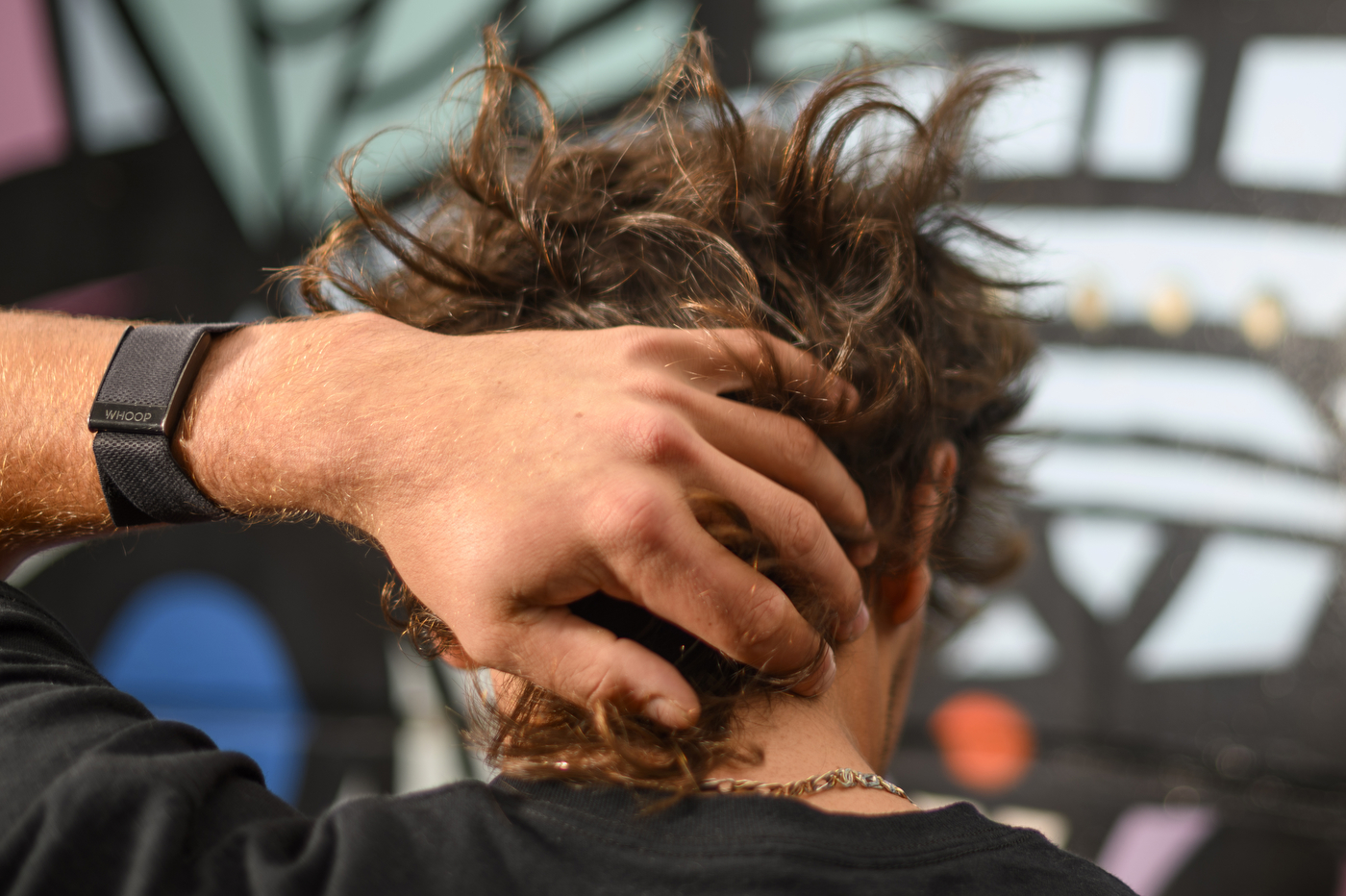 A person is running their hand through their curly hair. 