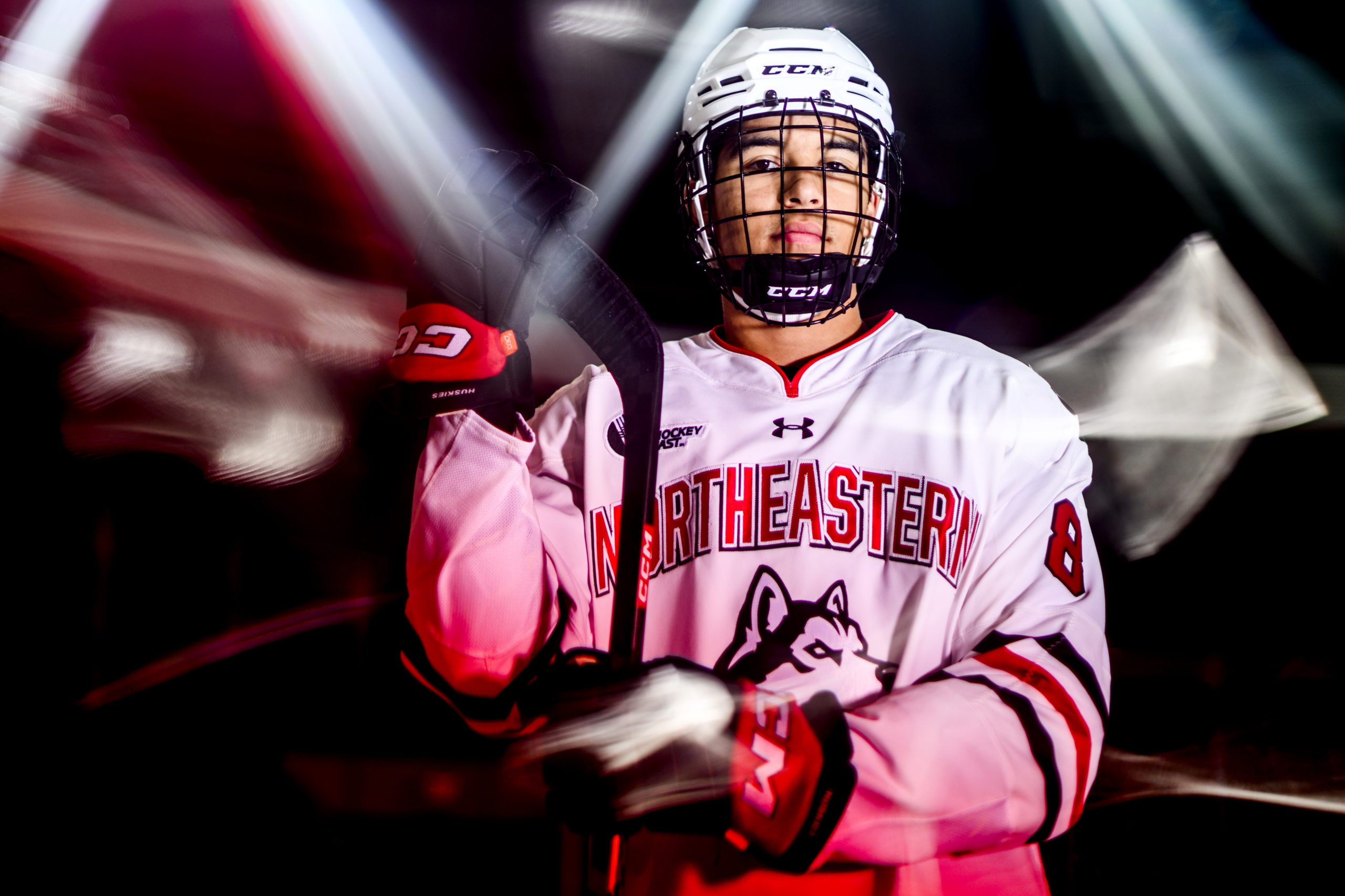 Jackson Dorrington looks directly at the camera holding a hockey stick and wearing a hockey helmet