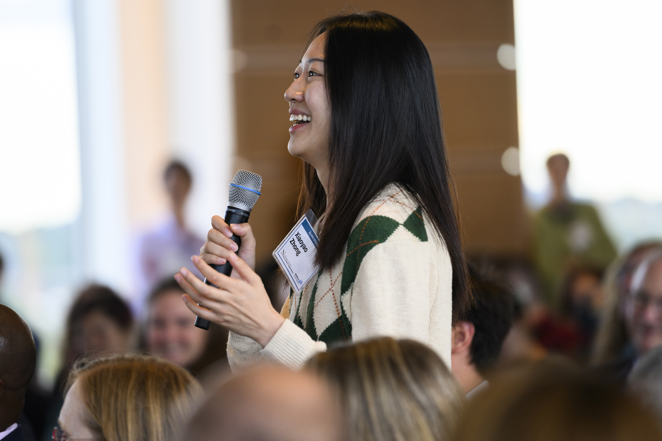 A person is holding a microphone at Northeastern's Khoury College's 40th anniversary.