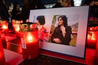 Lit candles are placed around framed pictures.