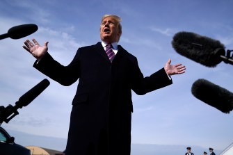 Headshot of former President Donald Trump surrounded by microphones.