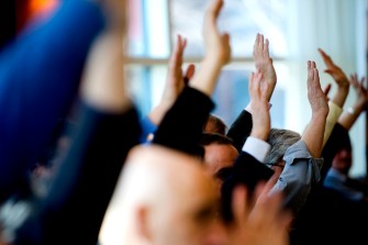 Hands raised at Northeastern's Faculty Senate meeting.