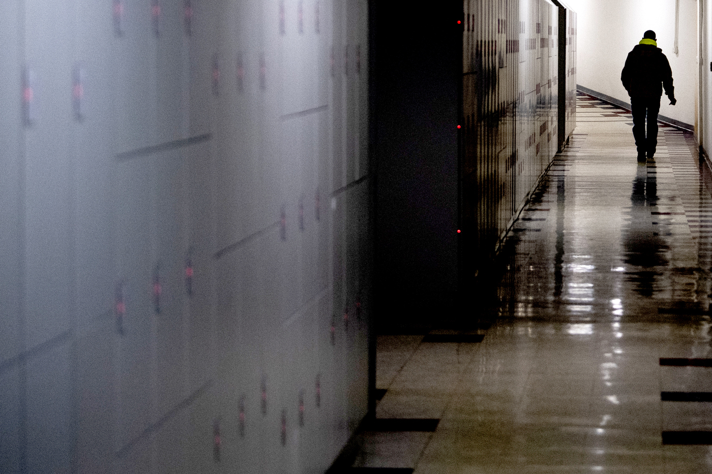 A person wearing a backpack is walking through a hallway on Northeastern's Boston campus. 