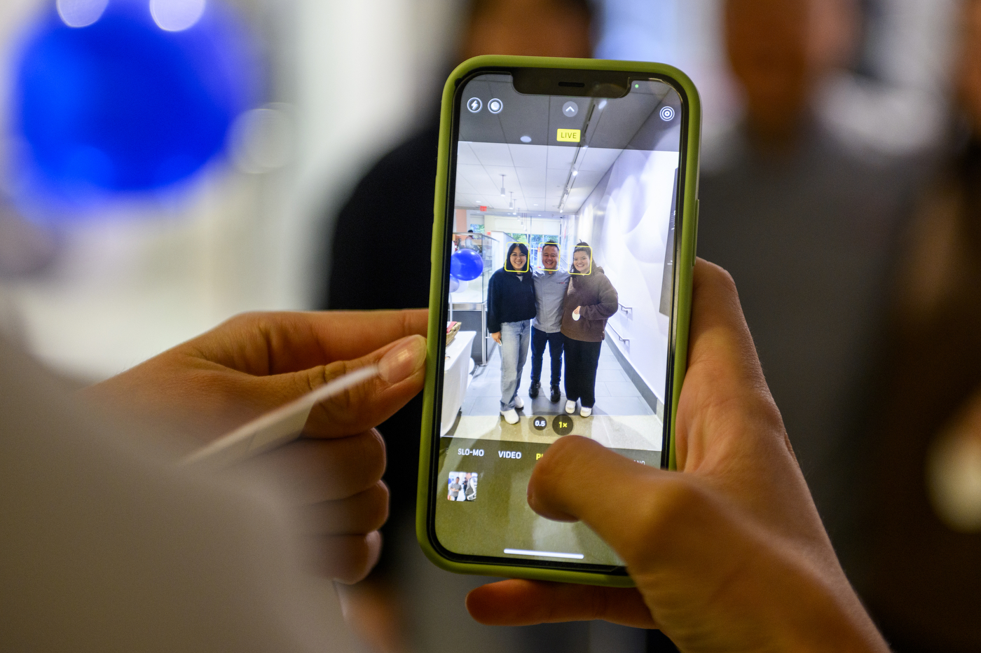 an iphone showing an image of chef tila posing with two students