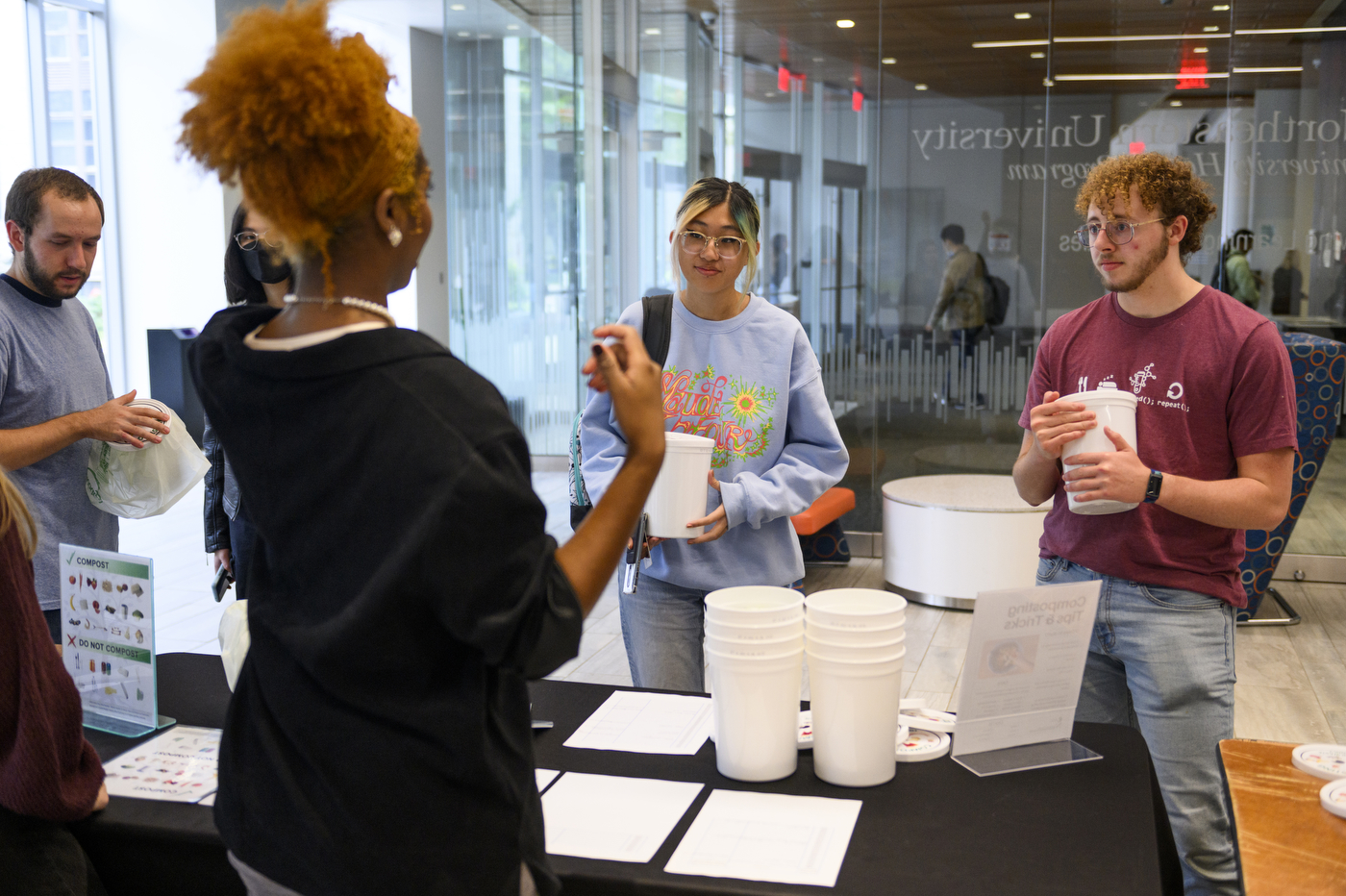 students picking up composting cups