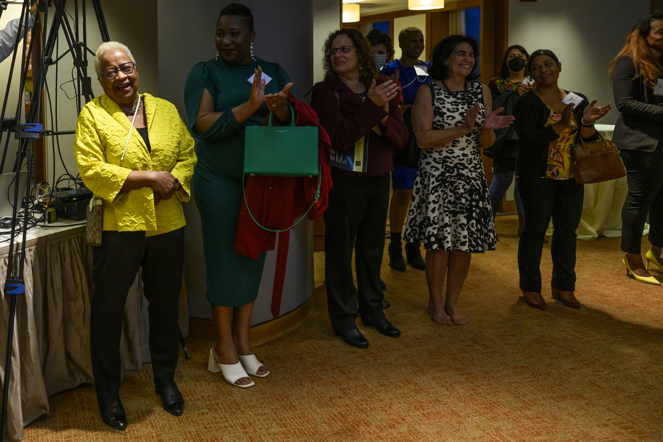 Margaret Burnham smiles as a group of people looks on and claps