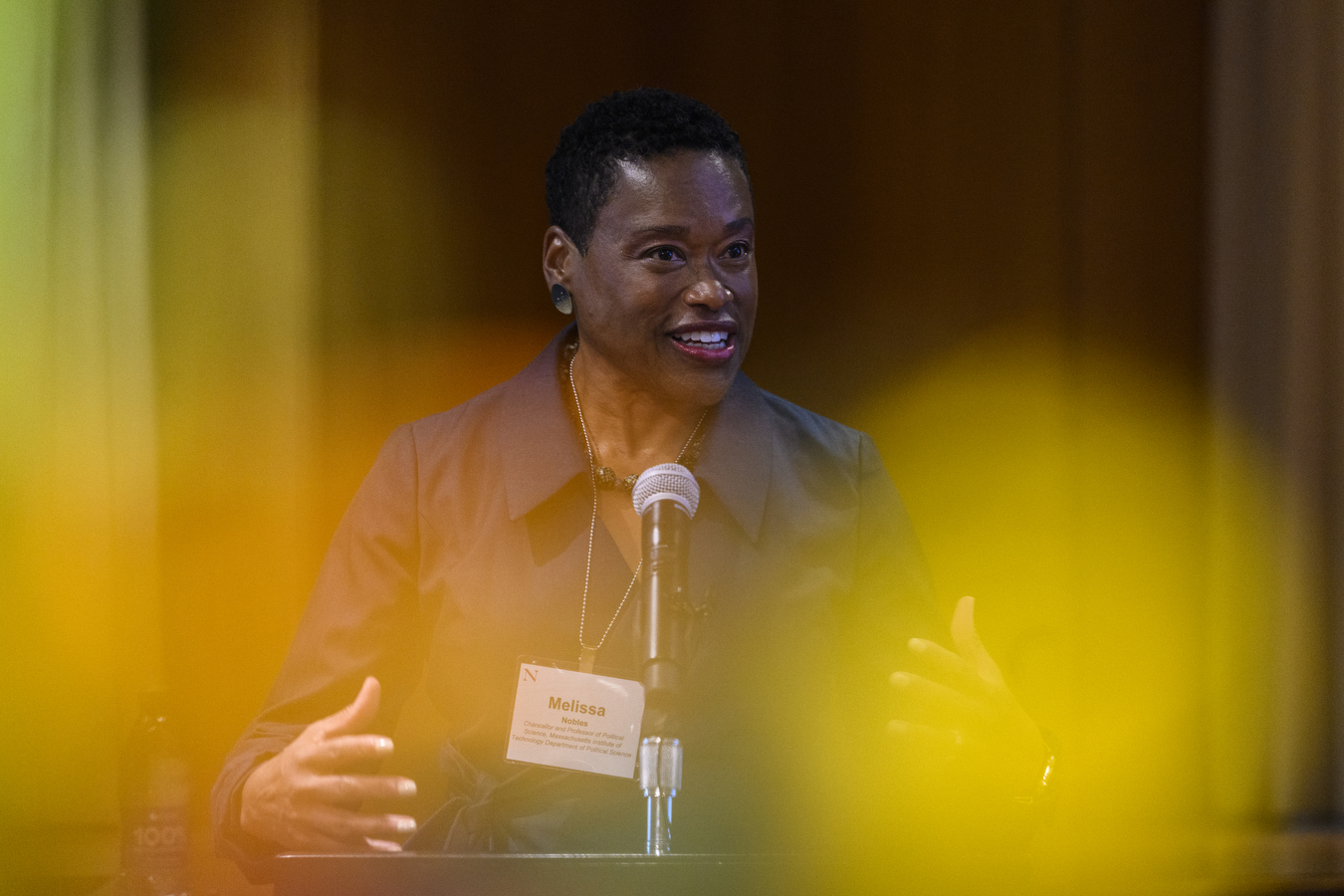 Melissa Nobles stands behind a podium and talks into a microphone