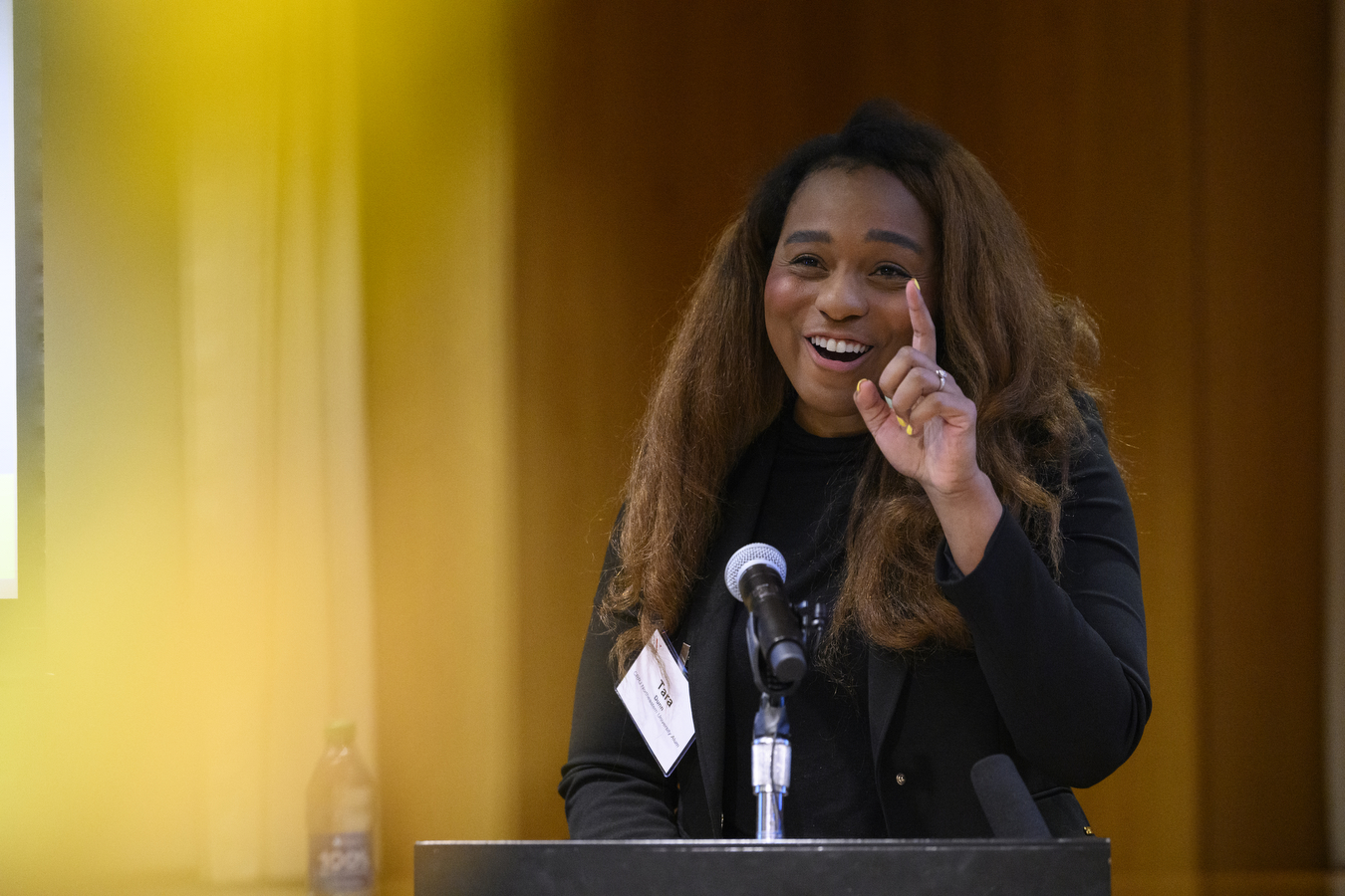 Tara Dunn stands behind a podium and speaks into a microphone