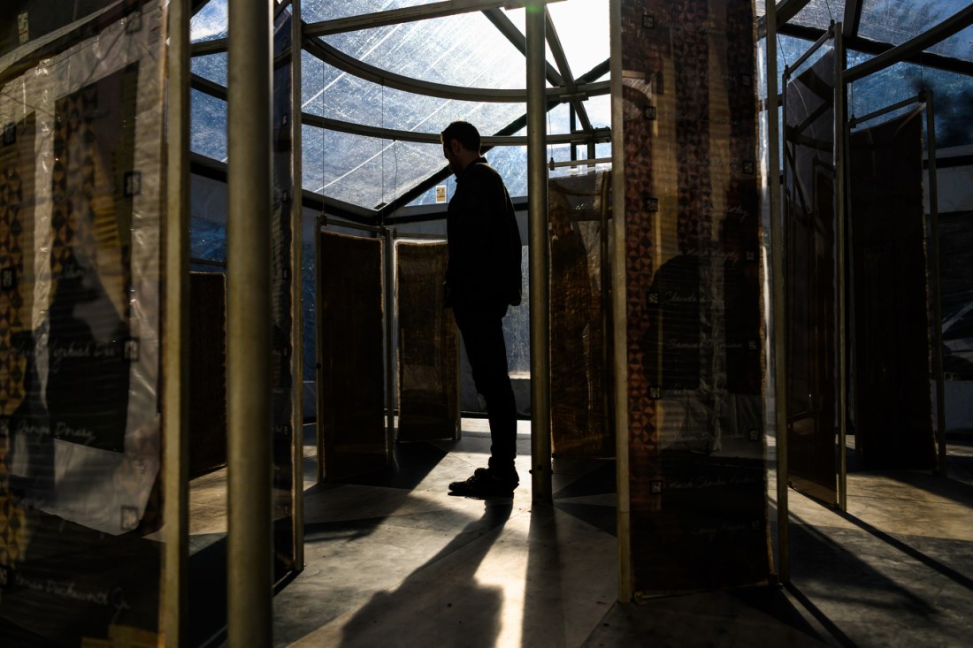 person standing in shadowy art exhibit