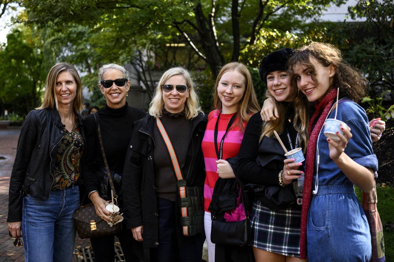 Six people stand next to each other while outside at Northeastern's Family and Friends Weekend.