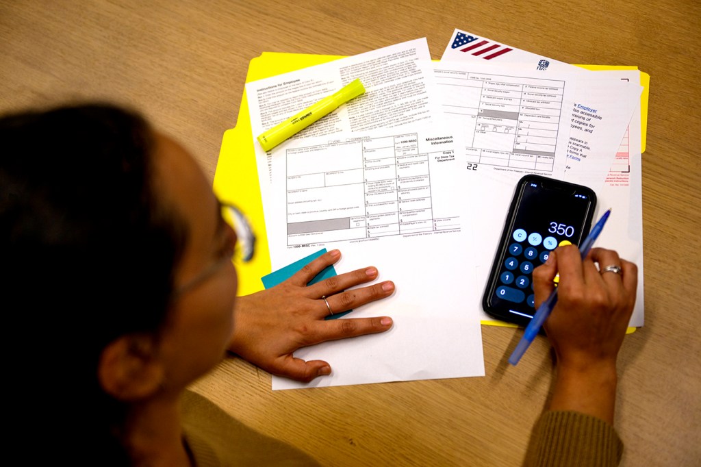 Woman filling out paperwork using a calculator