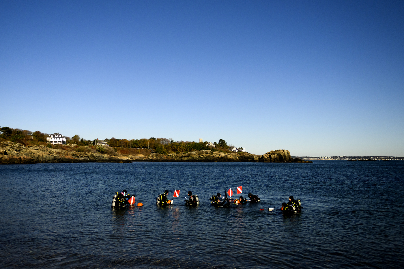 scuba divers preparing to dive underwater