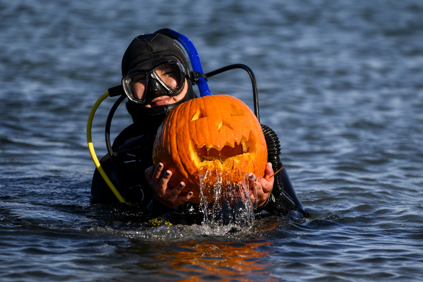 scuba diver holding a jack-o-lantern