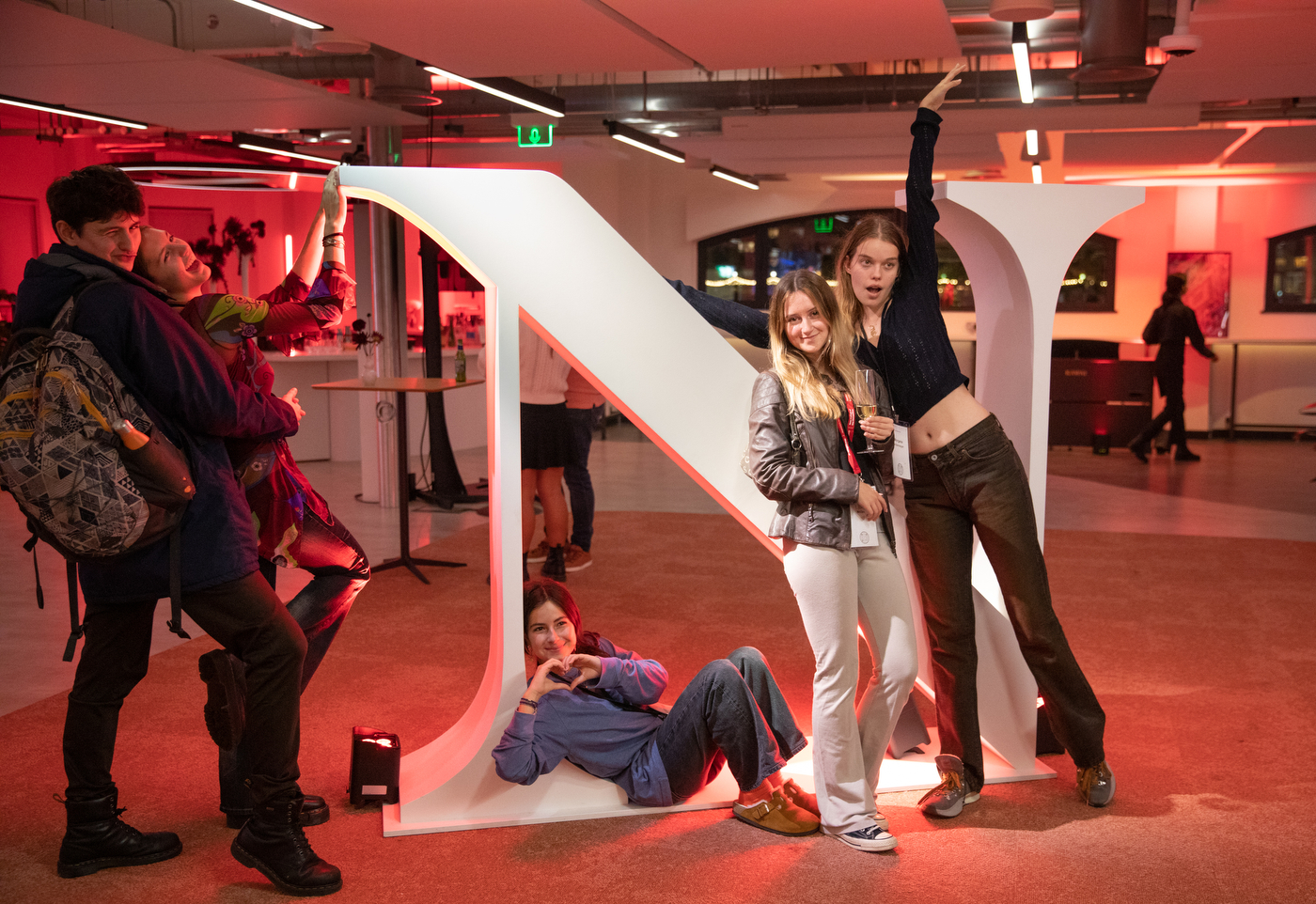 two people pose for a photo in front of an oversized Northeastern 'N' logo