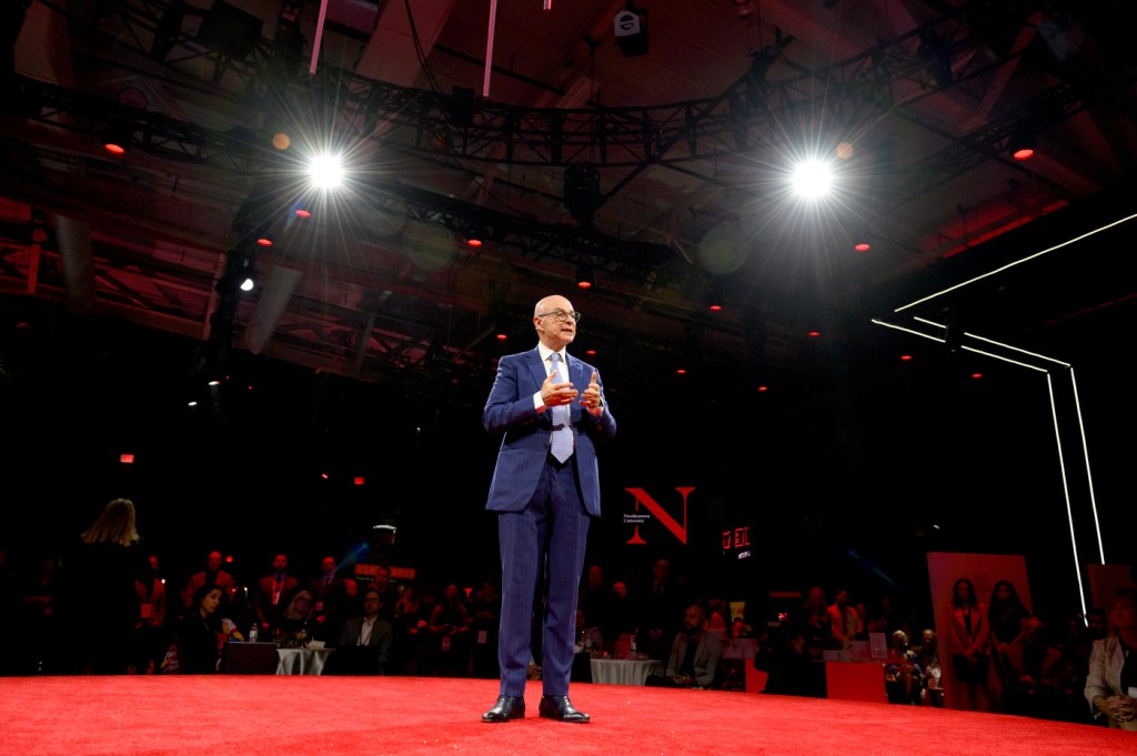 northeastern president aoun standing on red stage