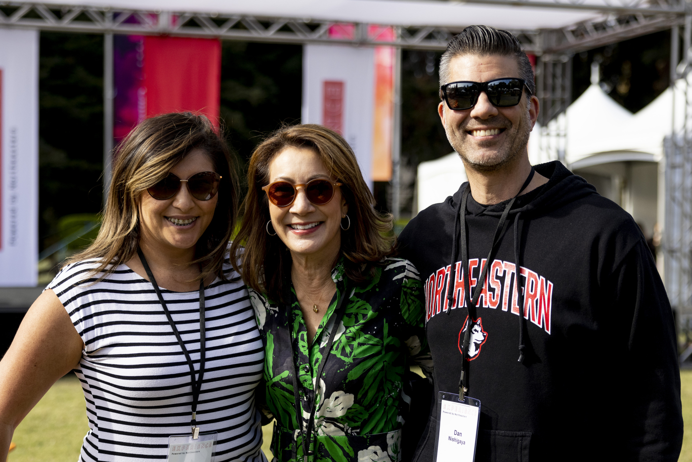 three people smile at the camera