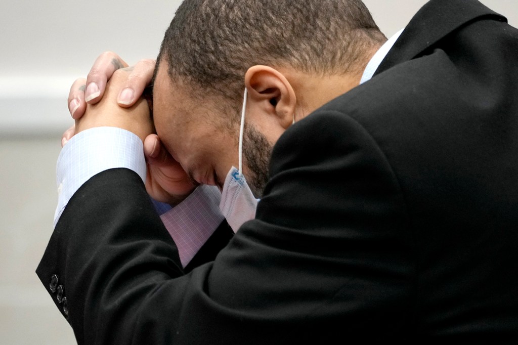 Darrell Brooks leans over, holding his head into his clasped hands