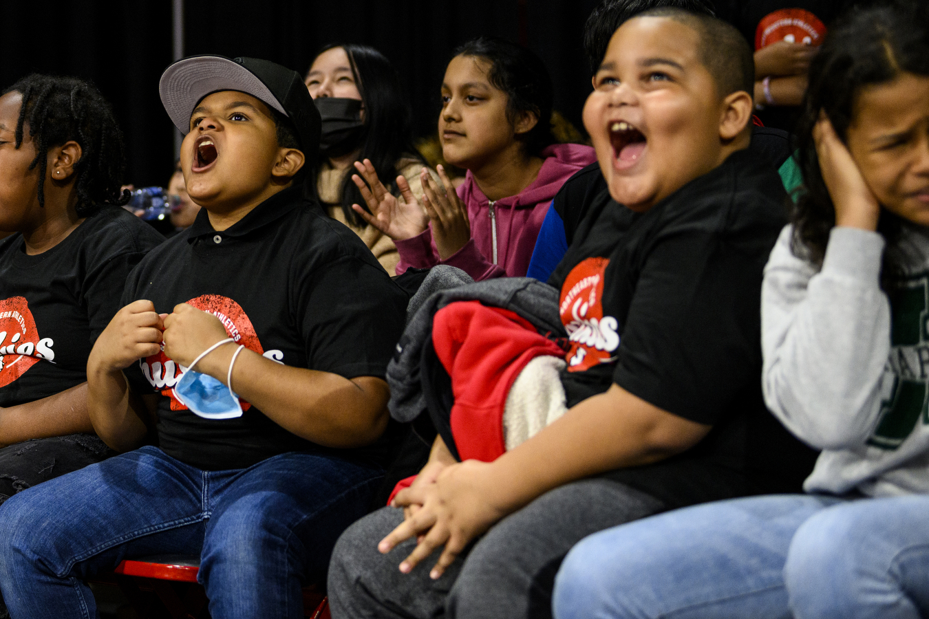 students cheering loudly at basketball game