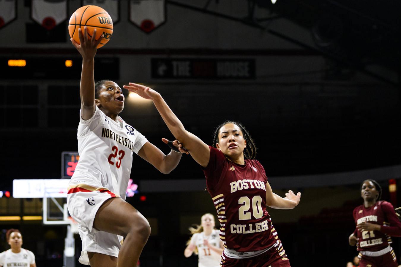 woman basketball player does a layup on basketball court