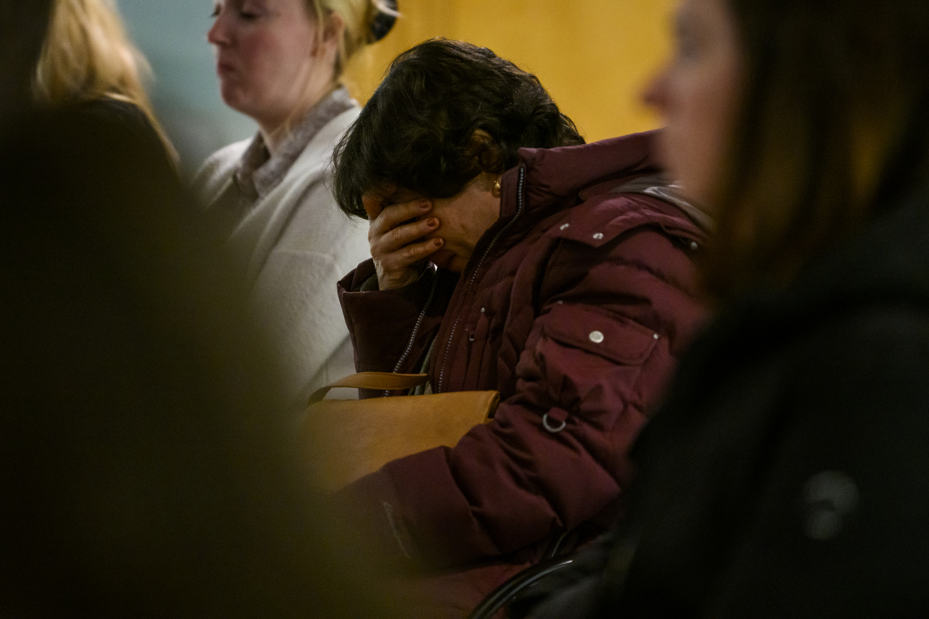 Person crying at bus crash vigil