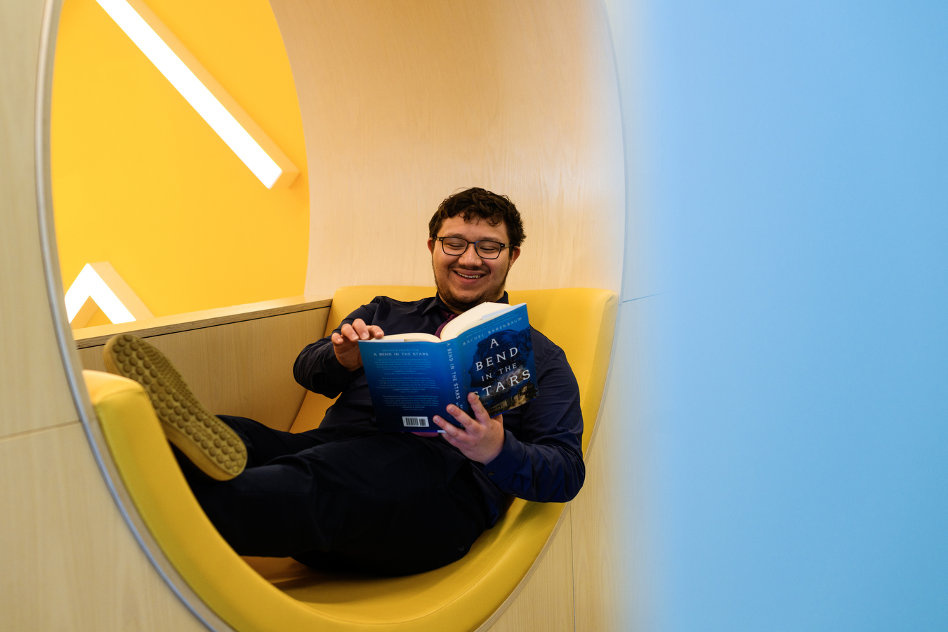 victor reading a book in a circle shaped chair