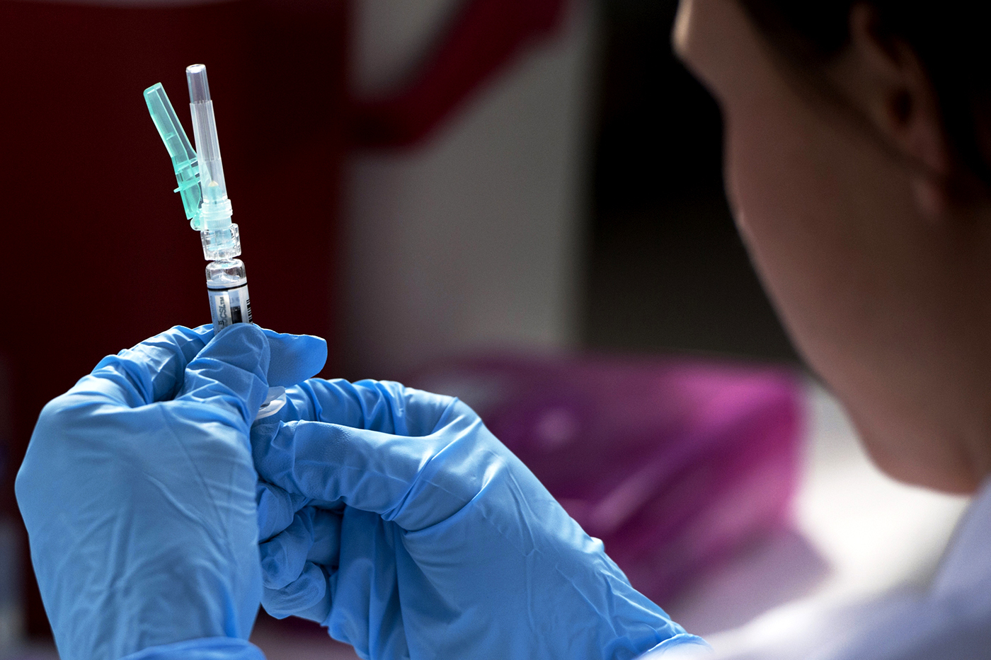 A medical worker readying a vaccine in a syringe