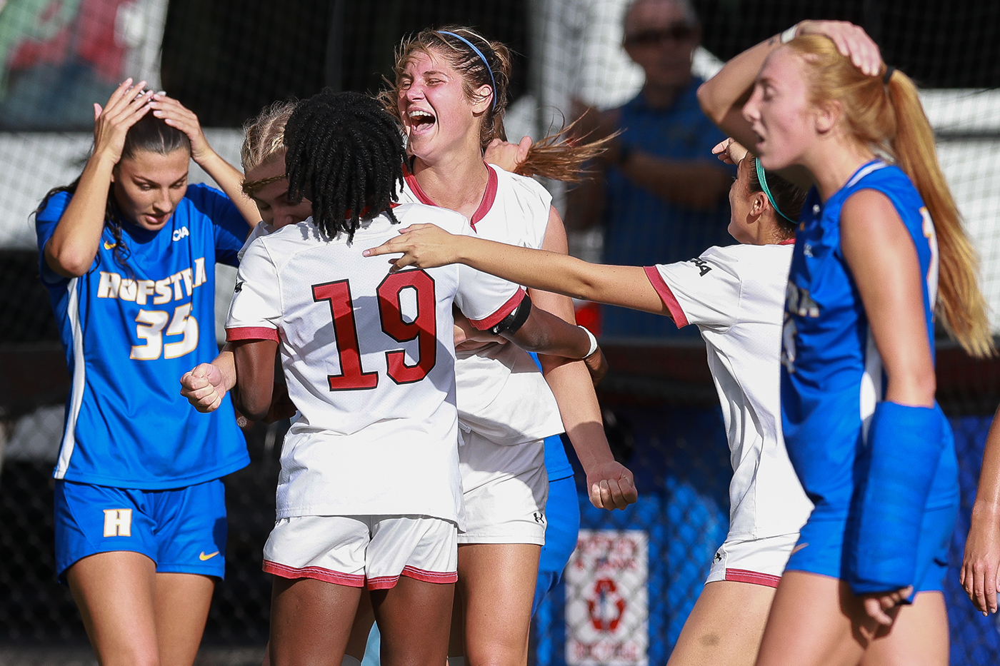 Players on the Northeastern women's soccer team are laughing with another group of soccer players. 