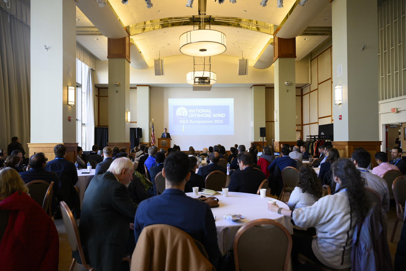 A large group of people sitting at round tables at this year's National Offshore Wind Research & Development Symposium 2022.