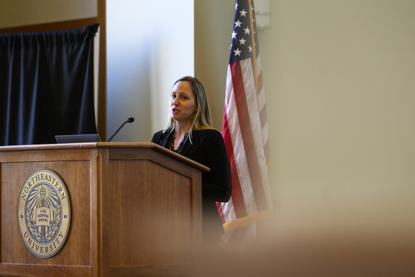 A person wearing a black shirt is standing at a podium. 