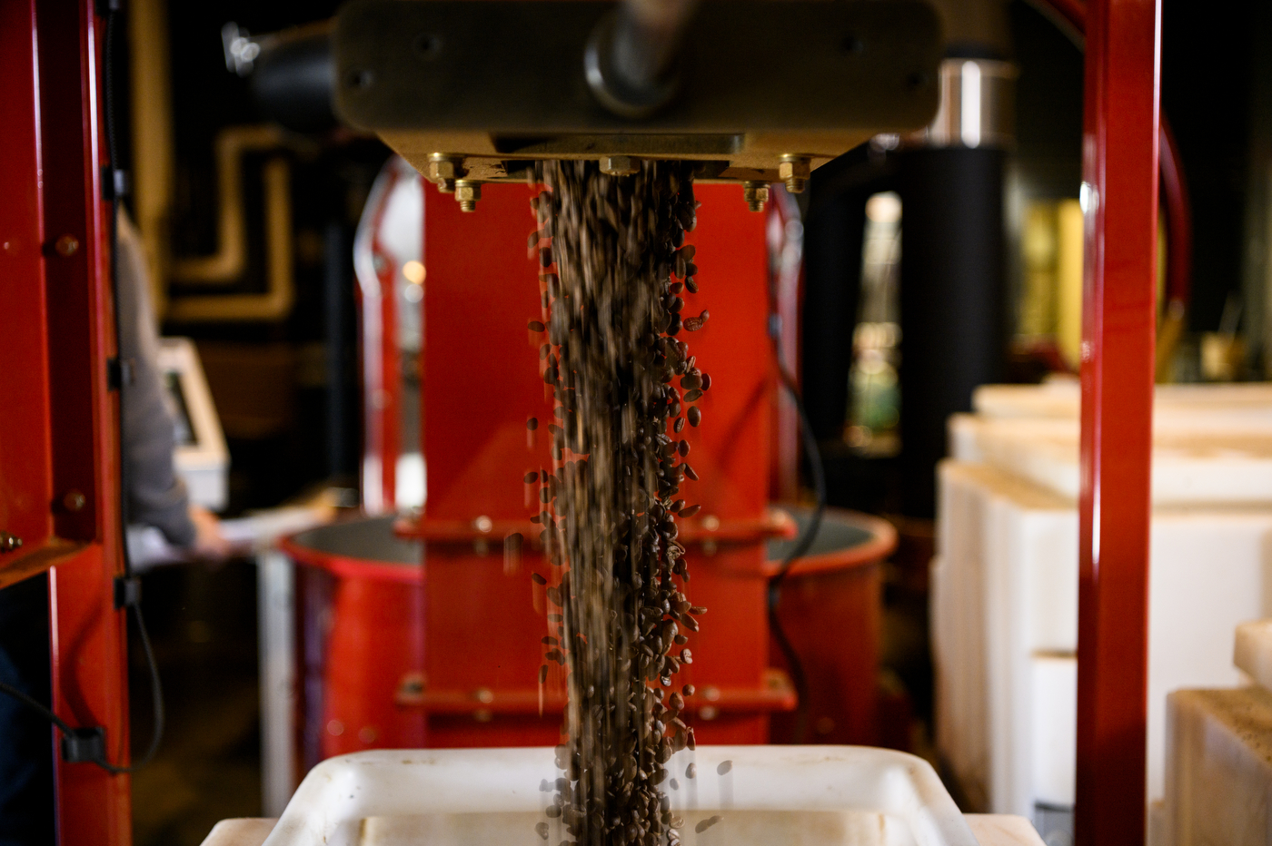 A black machine filters coffee beans. 