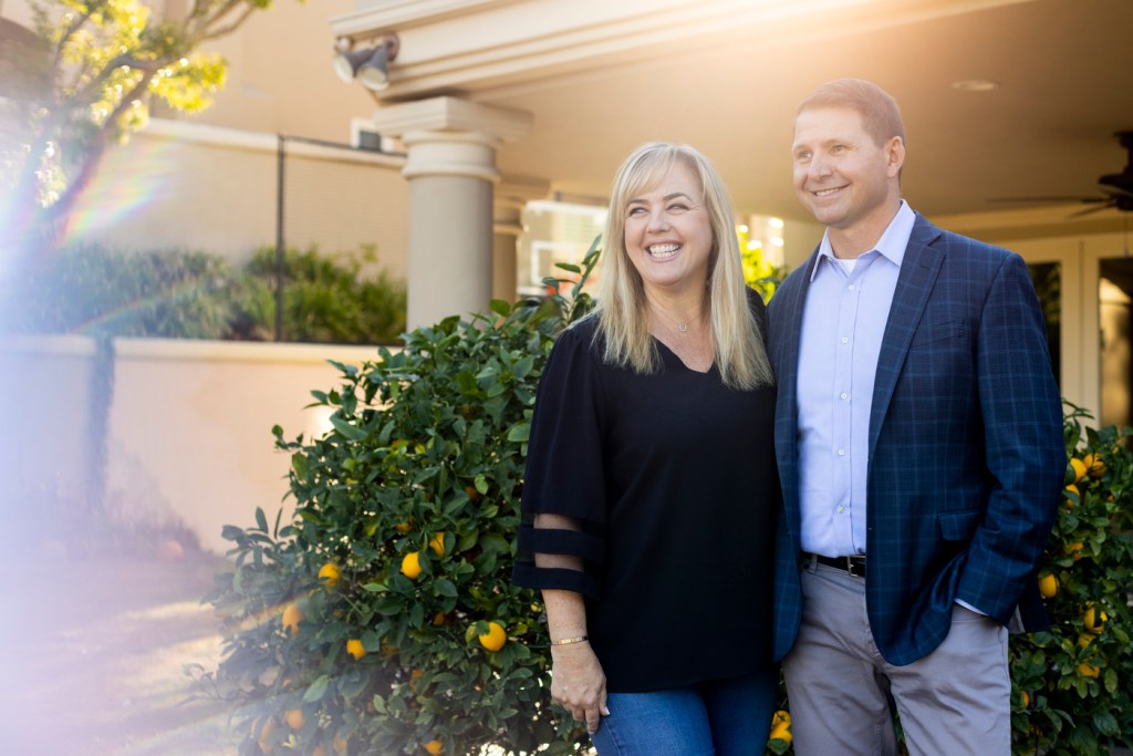 john and nicole nadolenco posing outside their family home