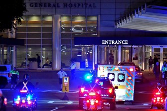 police cars escorting an ambulance to a hospital