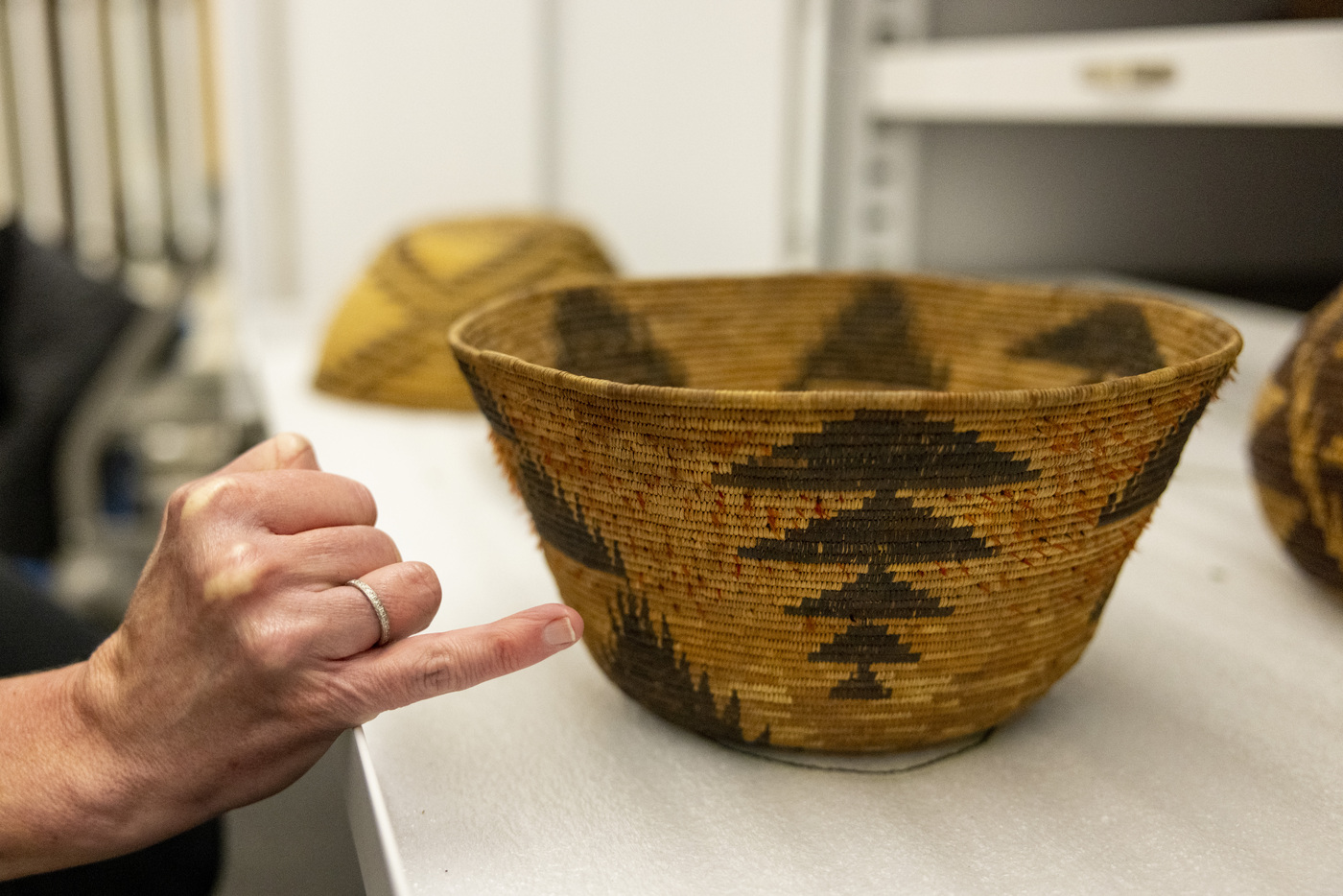 stephanie hanor pointing to a native american basket with her pinky