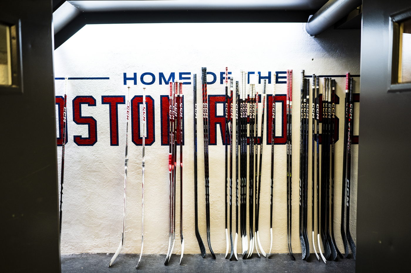 A white sign with red and blue text: "Home of the Boston Red Sox."