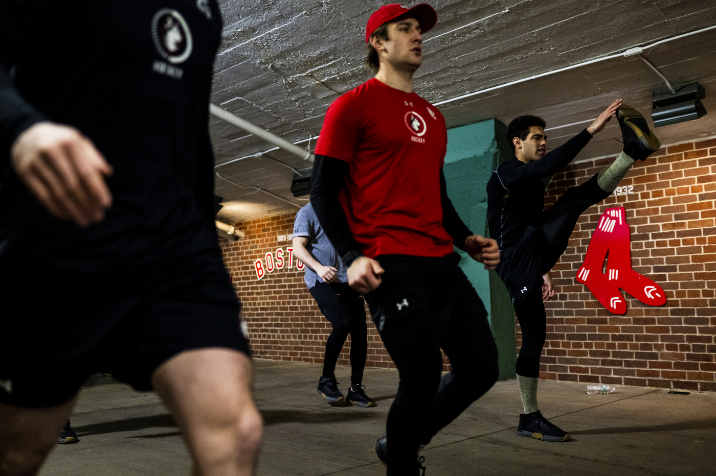 Four people exercising in the hall of Fenway Park. 