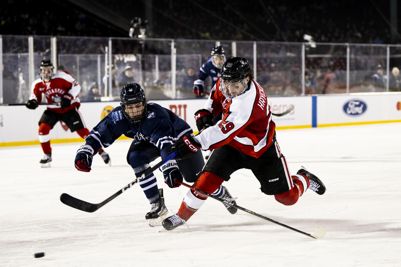 Four hockey players playing on an ice skating rink. 