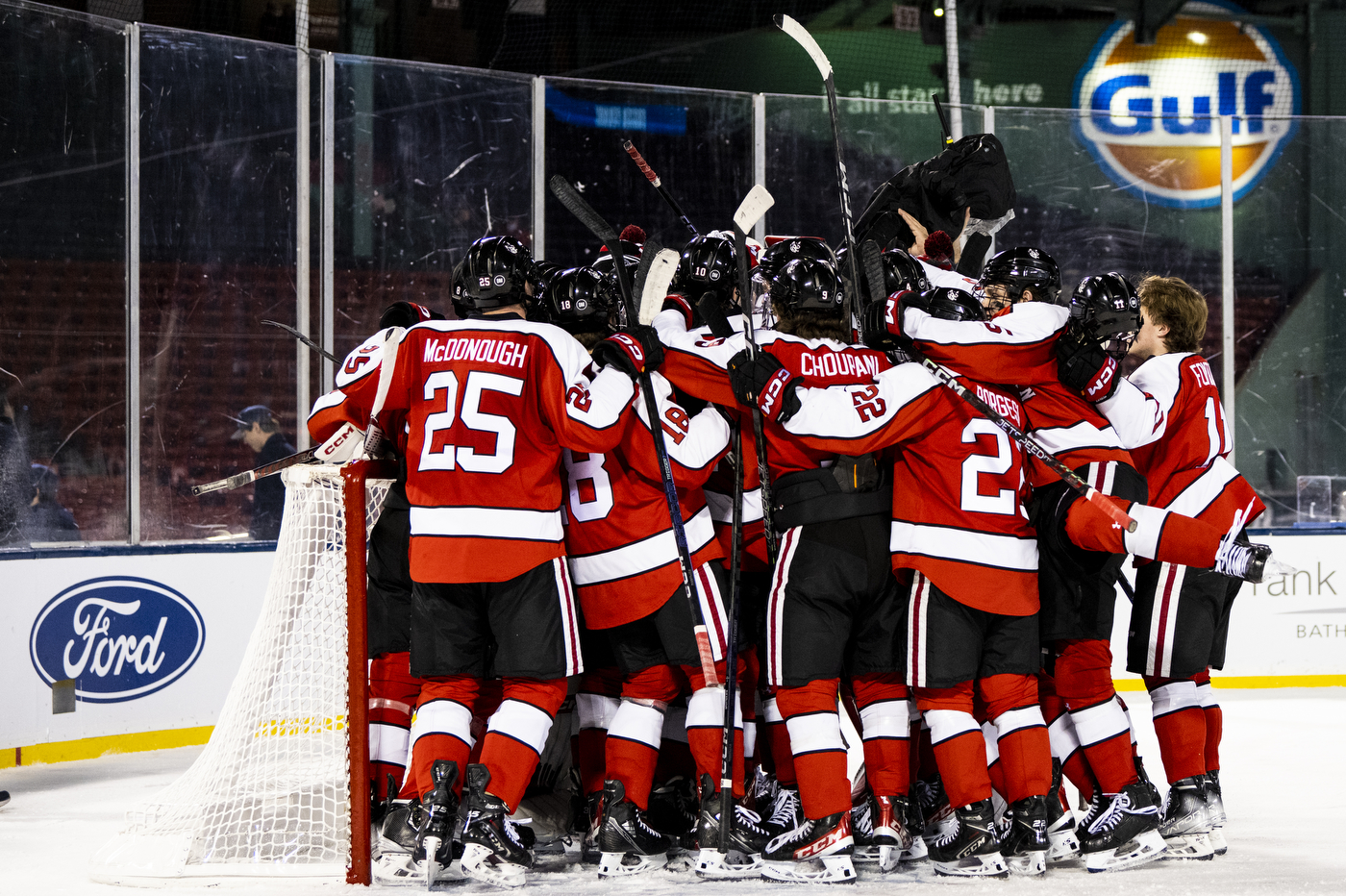 Northeastern Men's Hockey huddling around the goal