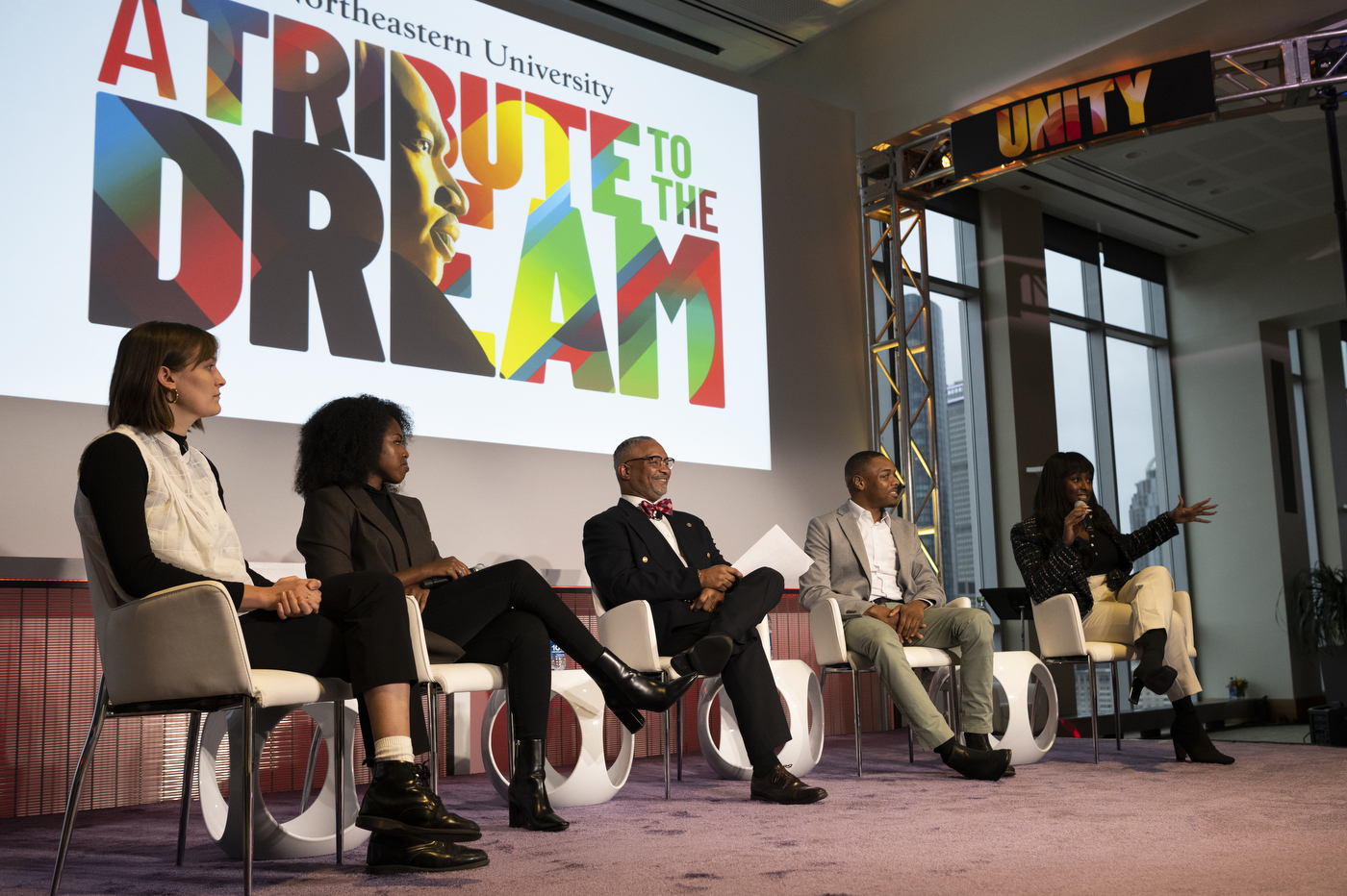 Five people sit on the stage at Northeastern's celebration of Martin Luther King Jr.