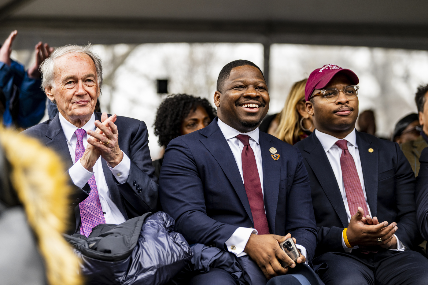 Three people smile and clap