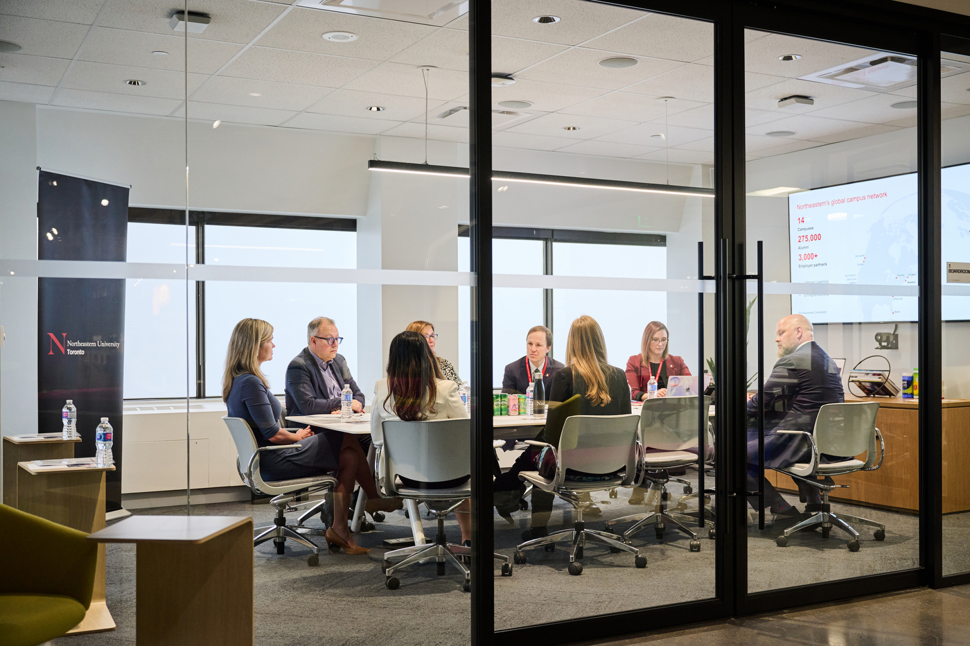 jill dunlop sitting at a conference table with a group of people